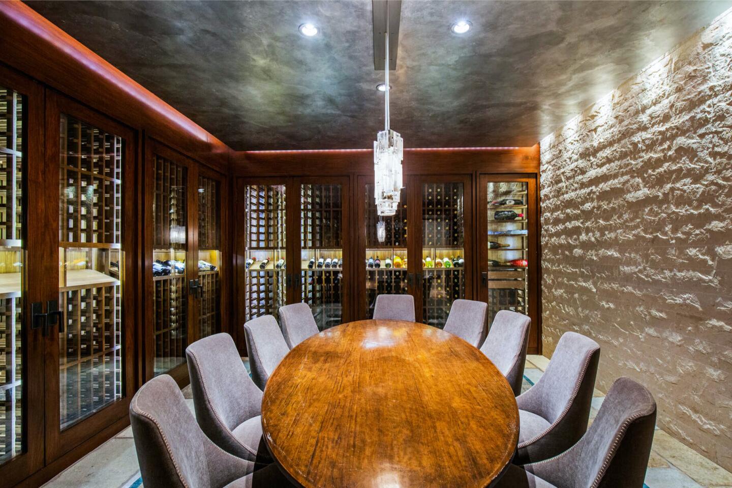 The wine cellar with a table surrounding by chairs.
