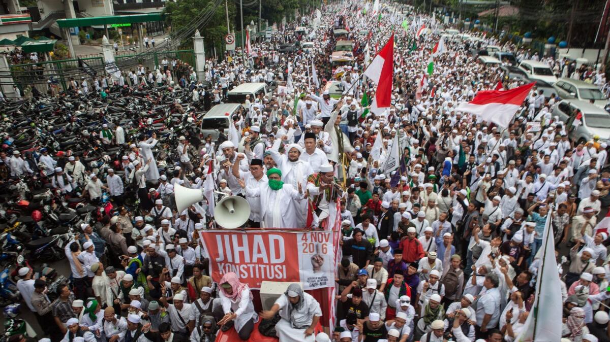 Protesters march in Jakarta, Indonesia, to demand the city's Christian governor be prosecuted for insulting Islam.