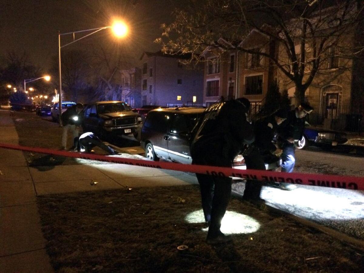 Chicago police officers investigate the scene of a shooting late Friday that wounded two women and a man. A series of shootings Friday and Saturday pushed the number of homicides in Chicago this year past 100.