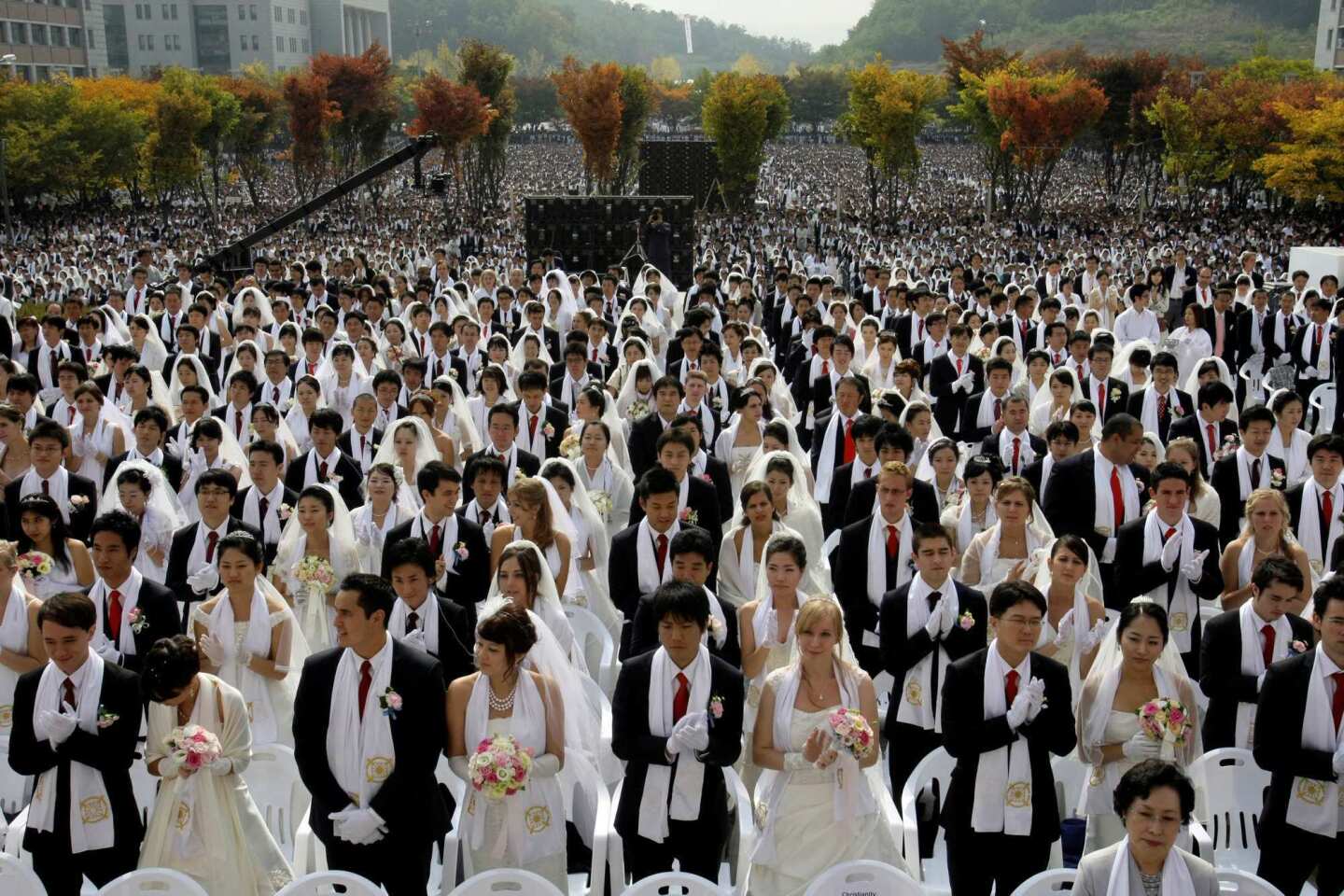 Couples from around the world participate in a mass wedding ceremony at Sun Moon University in Asan, South Korea, arranged by the reverend's Unification Church.