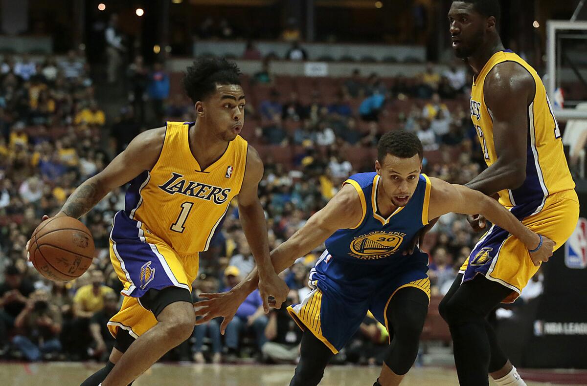 Lakers guard D'Angelo Russell uses a screen by center Roy Hibbert to drive past Warriors guard Stephen Curry in the first half of a preseason game Oct. 22.