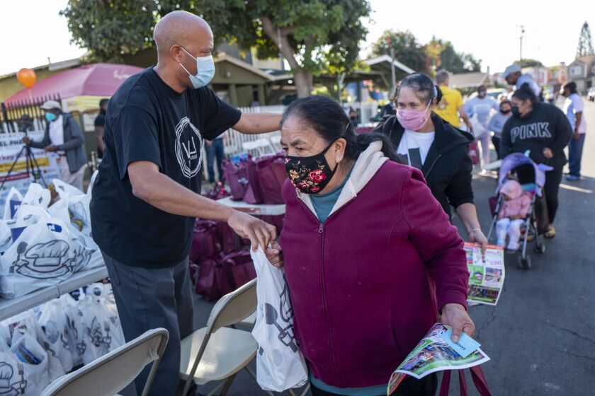 WATTS, CA - NOVEMBER 23: Volunteers are helping hand out 800 turkeys and other food items on Tuesday, Nov. 23, 2021 in Watts, CA. Sweet Alice Harris & Parents of Watts are giving away turkey's and other food items this year. This is her 57th year. (Francine Orr / Los Angeles Times)