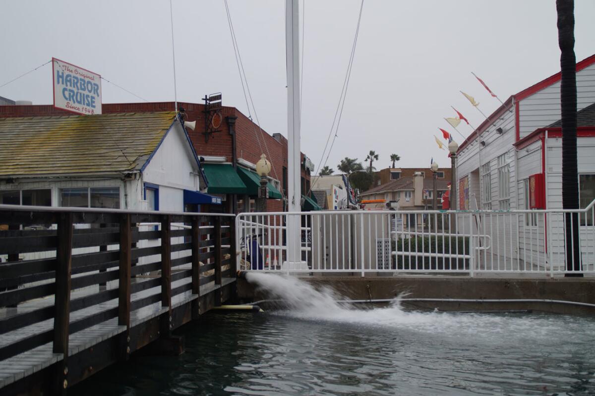 Newport Beach city crews manned several pumps Wednesday to get tidal water off the streets, like this one at Washington Street on the Balboa Peninsula.