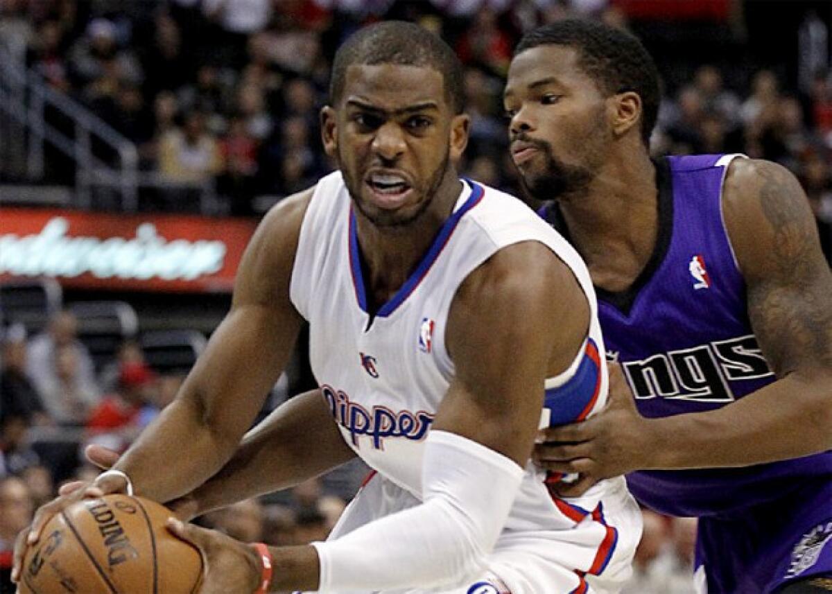 Chris Paul drives around Kings guard Aaron Brooks.