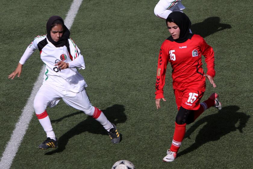 A Maihan player, left, vies for the ball against an Afghan Club player in their final of the Kabul Women's Premier League