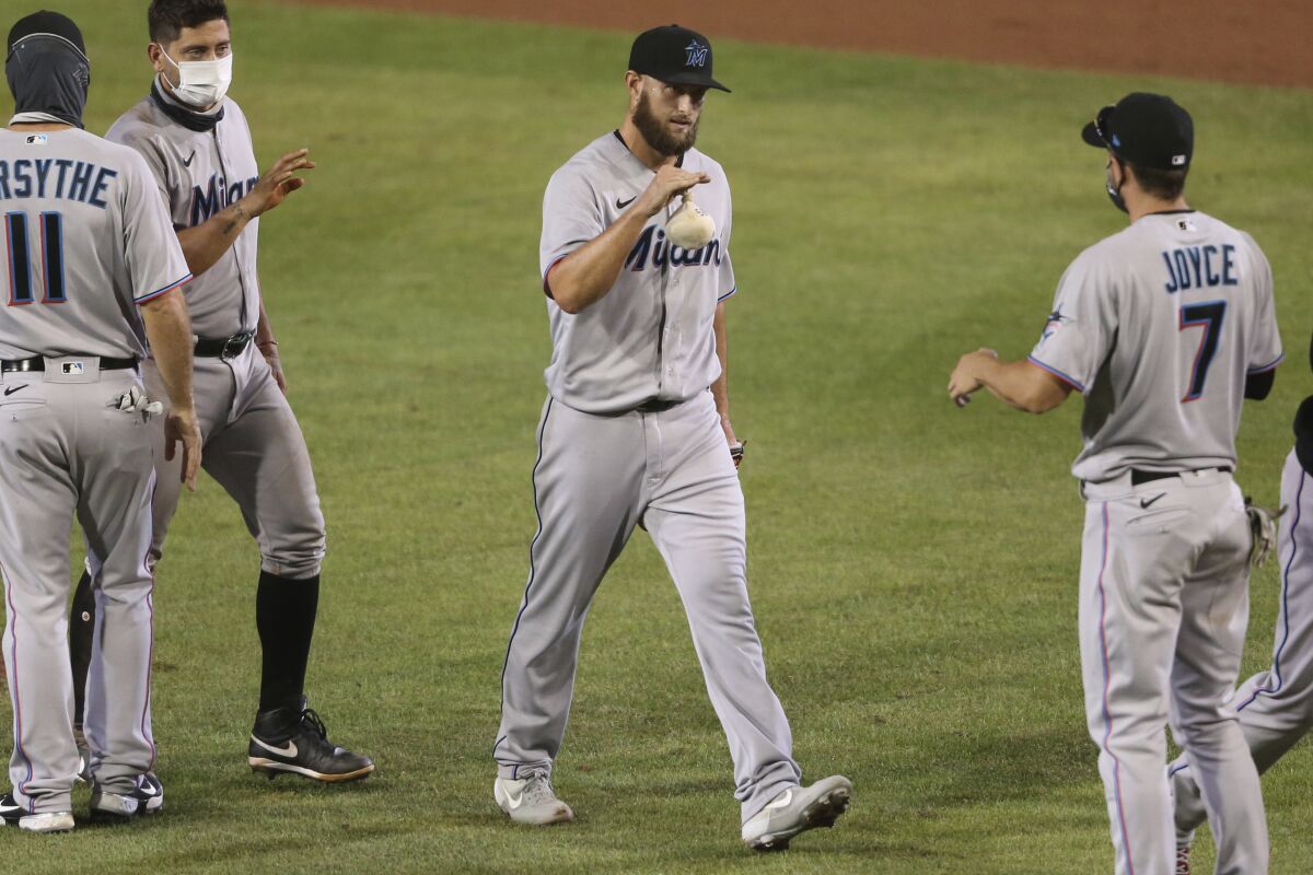 Miami Marlins pitcher Josh A. Smith celebrates his win with teammates following the tenth inning of a baseball game against the Toronto Blue Jays, Wednesday, Aug. 12, 2020, in Buffalo, N.Y. (AP Photo/Jeffrey T. Barnes)