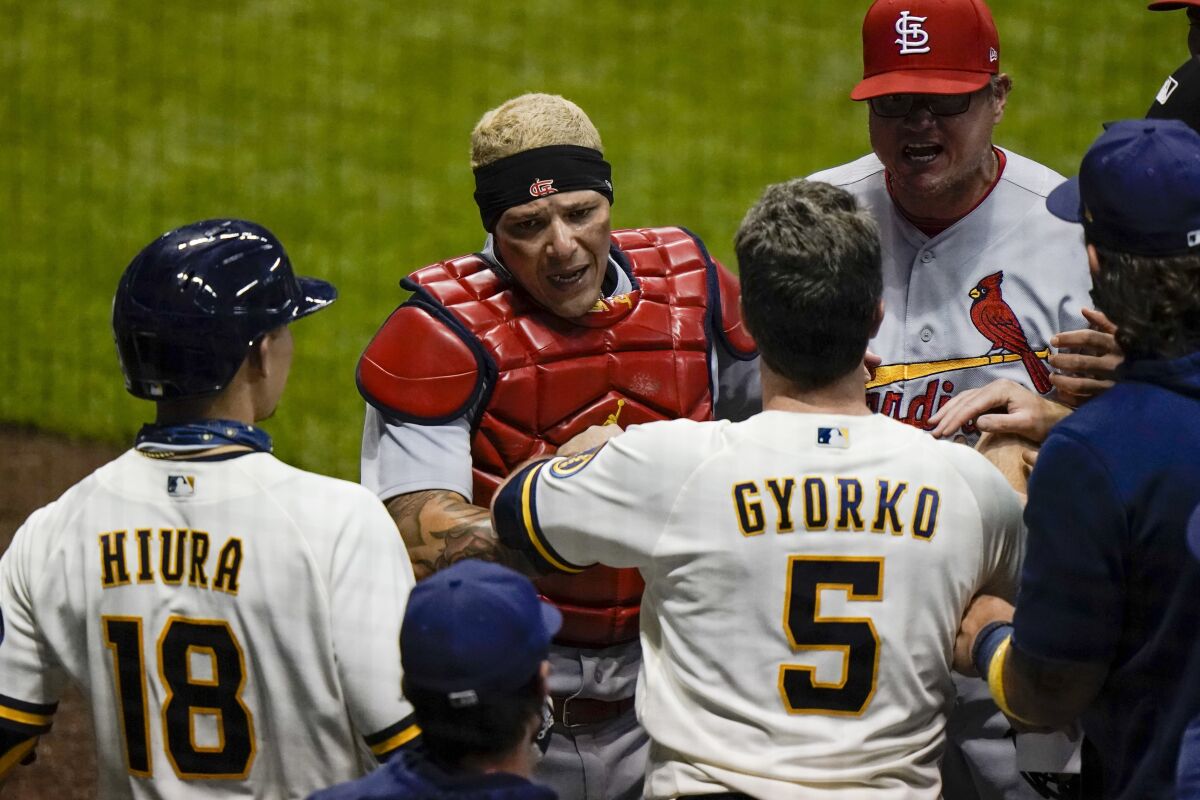 St. Louis Cardinals' Yadier Molina has words with Milwaukee Brewers' Keston Hiura and Jedd Gyorko during the fifth inning of a baseball game Tuesday, Sept. 15, 2020, in Milwaukee. (AP Photo/Morry Gash)