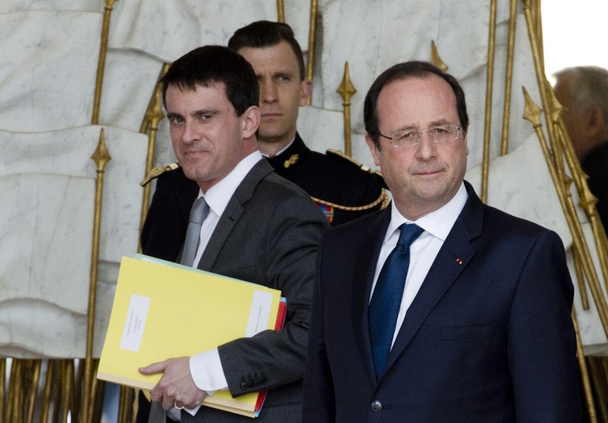 A file photo taken March 19 shows French Interior Minister Manuel Valls, left, and President Francois Hollande, right, leaving the Elysee Palace in Paris after the weekly cabinet meeting. Hollande named Valls as the nation's new prime minister on Monday.