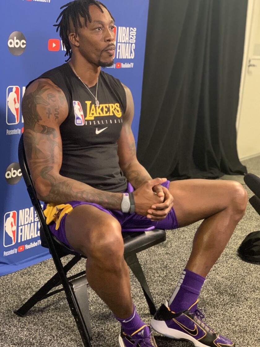 Lakers center Dwight Howard, in some purple-and-gold Kobe shoes by Nike, takes a break.