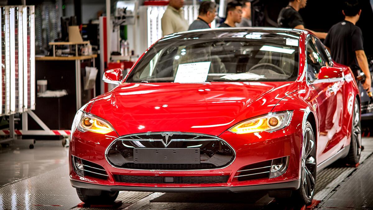 A Telsa car is readied for the final stages of preparation before being released from the assembly line at Tesla's factory in Fremont.