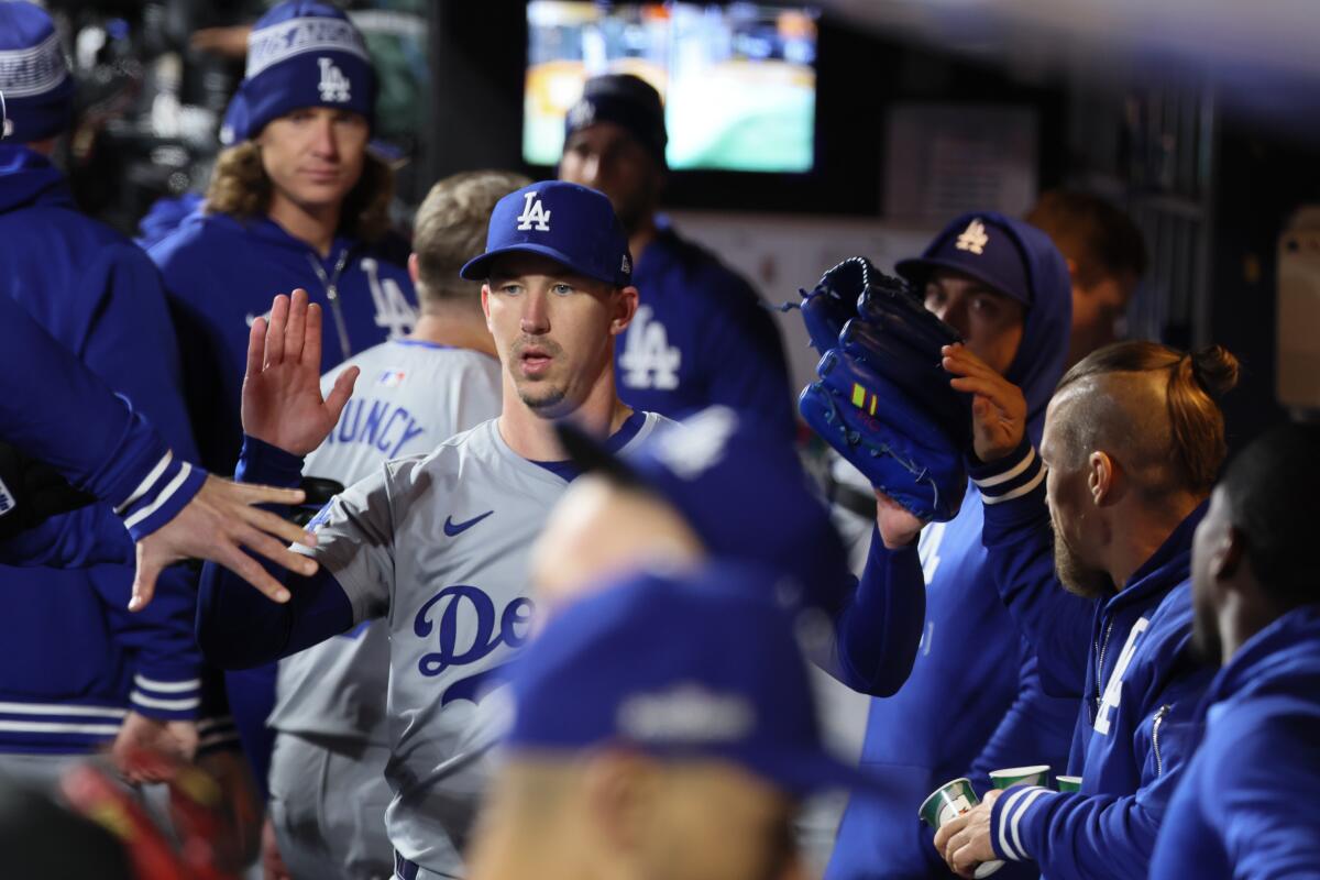 Dodgers pitcher Walker Buehler celebrates with teammates in the dugout after the fourth inning.