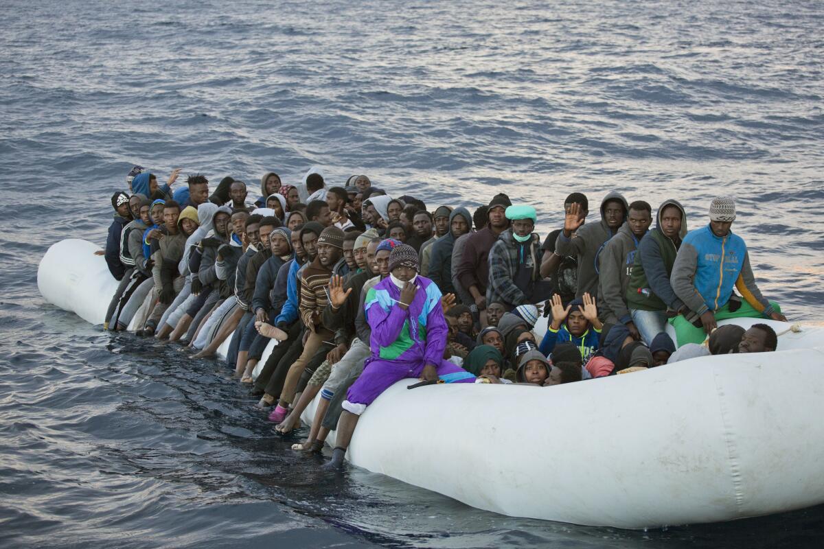 FILE - In this Feb. 3, 2017, file photo, migrants and refugees wait to be helped by members of the Spanish NGO Proactiva Open Arms, as they crowd aboard a rubber boat sailing out of control in the Mediterranean Sea about 21 miles north of Sabratha, Libya. A U.N. migration agency official expressed concerns Friday, Sept. 17, 2021, over the disappearance of thousands of Europe-bound migrants who were intercepted and returned to Libya as more and more desperate people risk their lives trying to cross the Mediterranean Sea to Europe.(AP Photo/Emilio Morenatti, File)