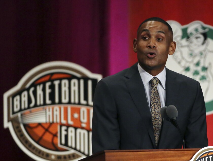 Grant Hill speaks at a lectern with the Basketball Hall of Fame logo behind him.