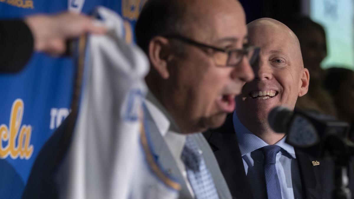 UCLA athletic director Dan Guerrero, left, introduces Mick Cronin, as the university's new men's basketball coach during a news conference Wednesday.