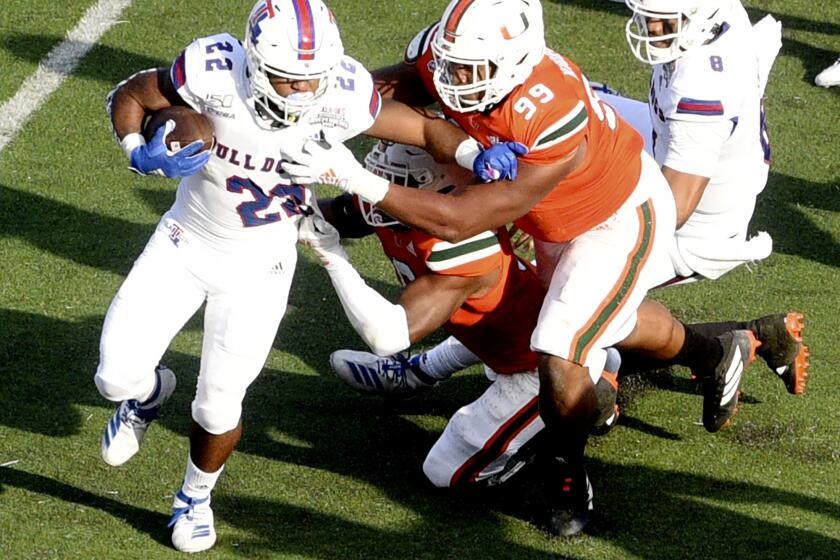Louisiana Tech's Israel Tucker, left, runs with the ball during the game against Miami during the first half of the NCAA college football Independence Bowl, Thursday, Dec. 26, 2019, at Independence Stadium in Shreveport, La. (Henriette Wildsmith/The Shreveport Times via AP)