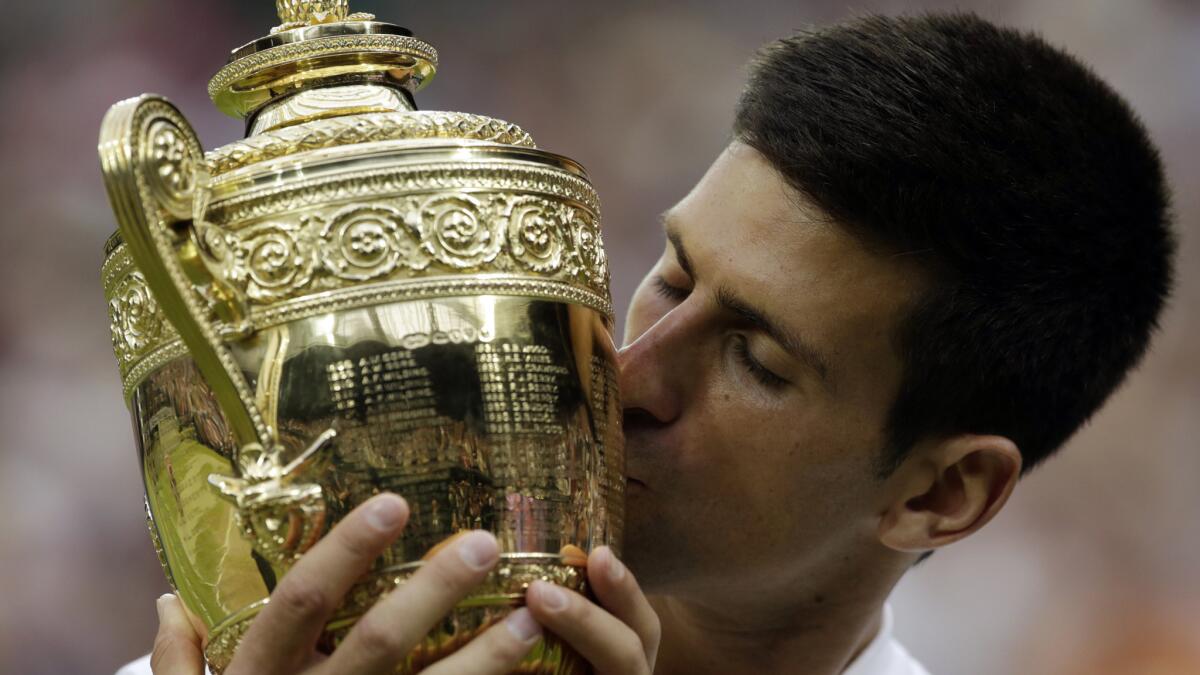 Novak Djokovic kisses the Wimbledon trophy after defeating Roger Federer for the men's singles title on Sunday.