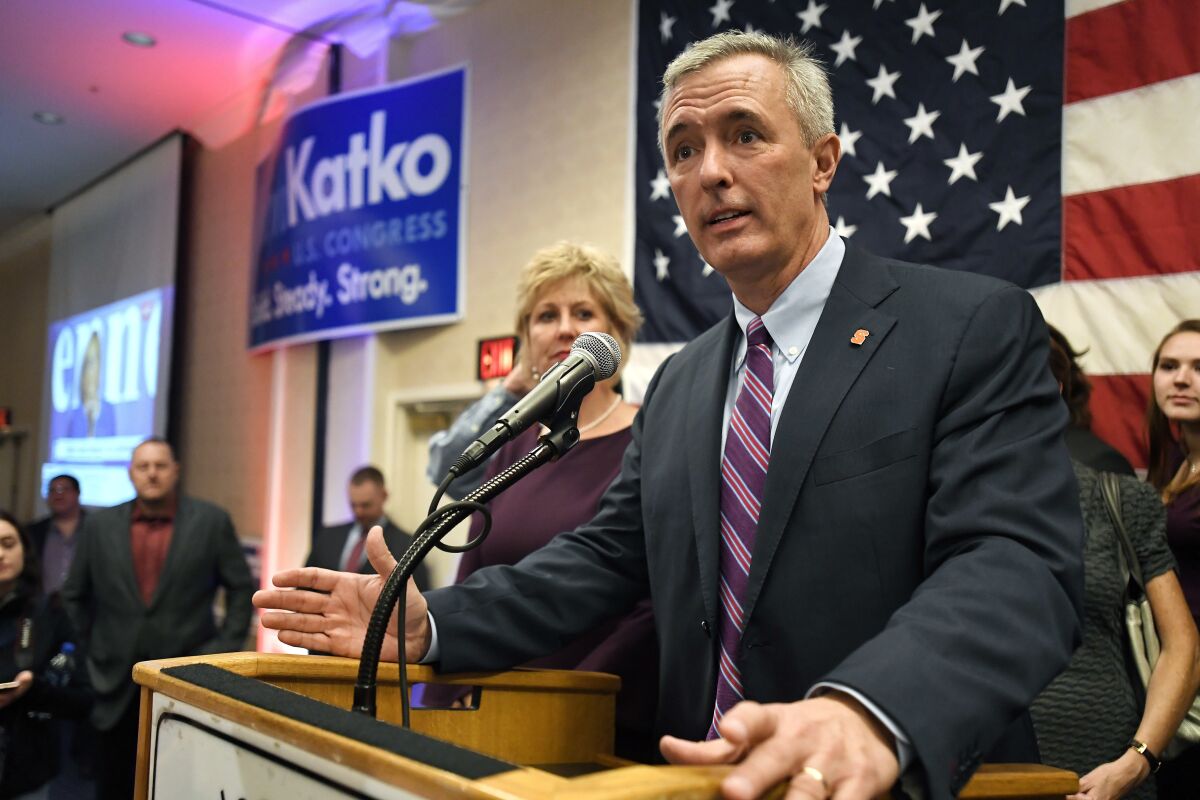 John Katko stands at a podium in front of a U.S. flag and speaks into a microphone.