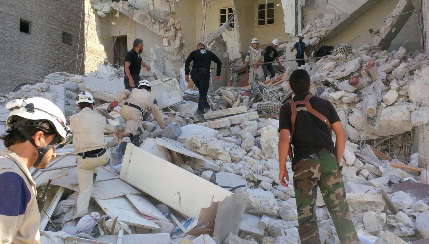Members of Aleppo's civil defense team try to rescue a woman trapped under rubble after her home was sheared in half by a government barrel bomb attack.