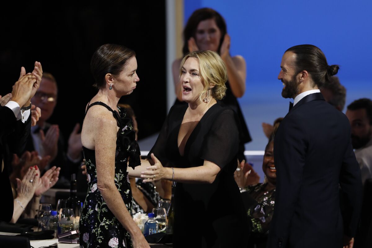 Julianne Nicholson, left, and Kate Winslet stand at a table at the Emmy Awards.
