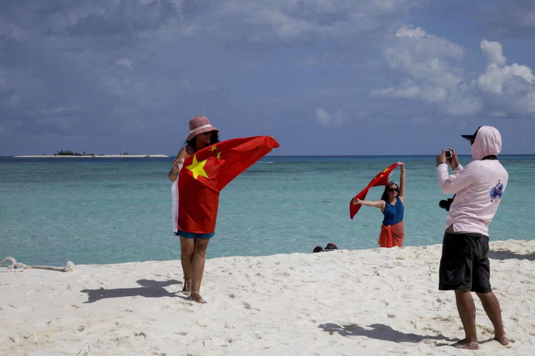 Chinese tourists take photos with their national flag during a visit to the Paracels in 2014