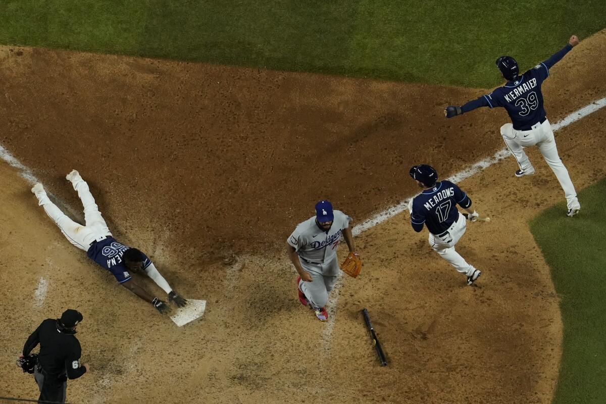 Tampa Bay Rays' Randy Arozarena touches after scoring the winning run against the Los Angeles Dodgers.