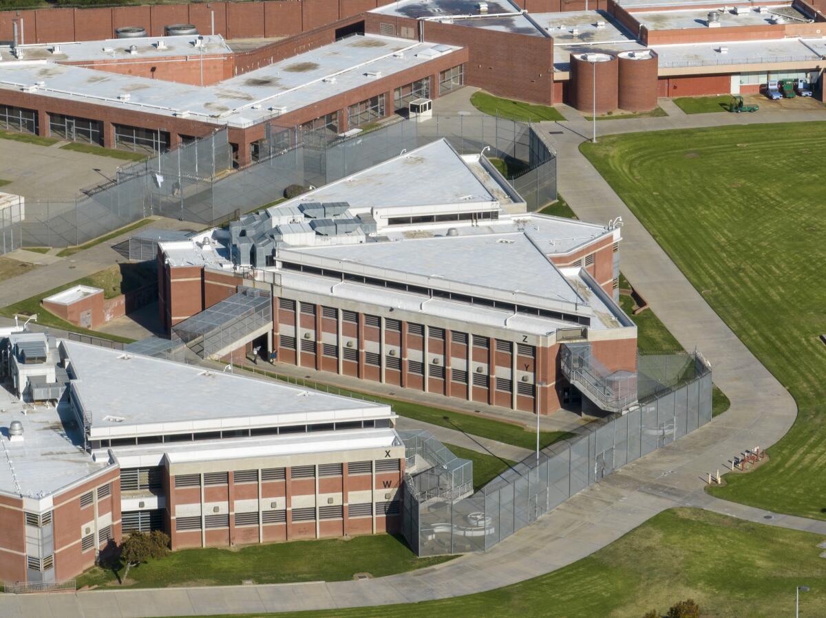 A bird's-eye view of red-brick buildings with white roofs and lawns 