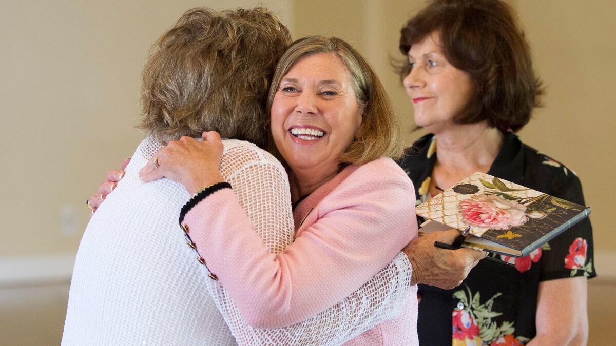 Barbara Crane, Woman's Club of Laguna Beach president for the past three years, greets friend and board member Elsa Brizzi on Friday during a ceremony honoring Crane as the club's Woman of the Year.