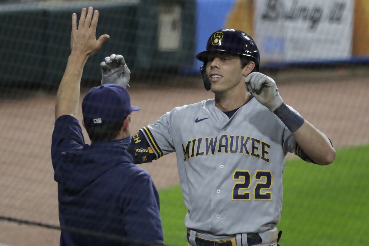 Milwaukee Brewers' Christian Yelich, right, celebrates with manager Craig Counsell after hitting an inside-the-park home run against the Chicago White Sox during the fifth inning of a baseball game in Chicago, Thursday, Aug. 6, 2020. (AP Photo/Nam Y. Huh)
