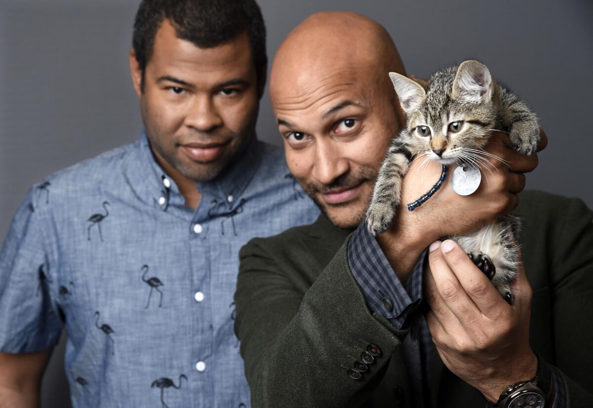 Jordan Peele, left, and Keegan-Michael Kay show off a cat like the one who stars with them in "Keanu."