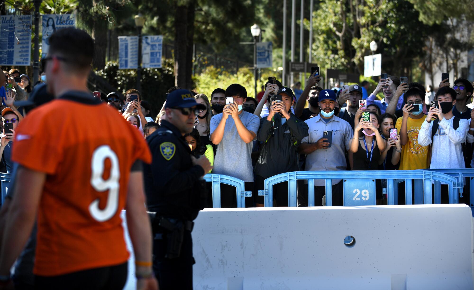 Fans watch Bengals quarterback Joe Burrow leave the practice field.