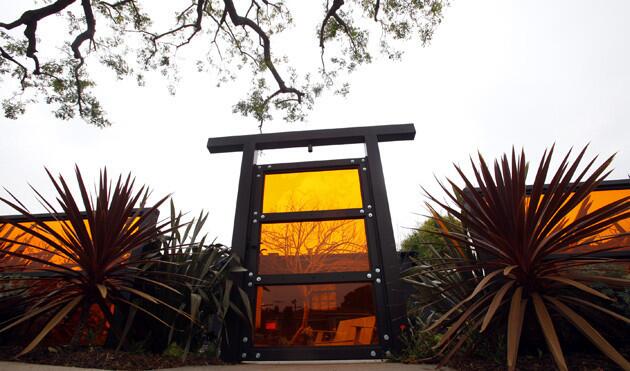 Landscape architect Dale Newman started in the front with a nod to Rash's boisterous side. A redwood-framed garden gate and fence are made with orange plexiglass from Solter Plastics. "They are really interesting, and you can see through them," Newman said of the panels, whose color was chosen to offset the gunmetal gray exterior of the house. "It gives the frontyard a crazy glow. In the daytime, the sun shines through them and gives an unusual cast over the plants."