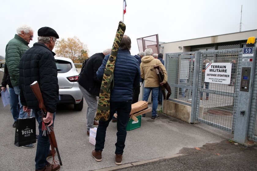 People wait to bring back their weapons to the Ustaritz gendarmerie, southwestern France, Thursday, Dec.1, 2022. France has launched a nationwide push to collect millions of old firearms; remnants of the two World Wars or long-abandoned hunting habits. (AP Photo/Bob Edme)
