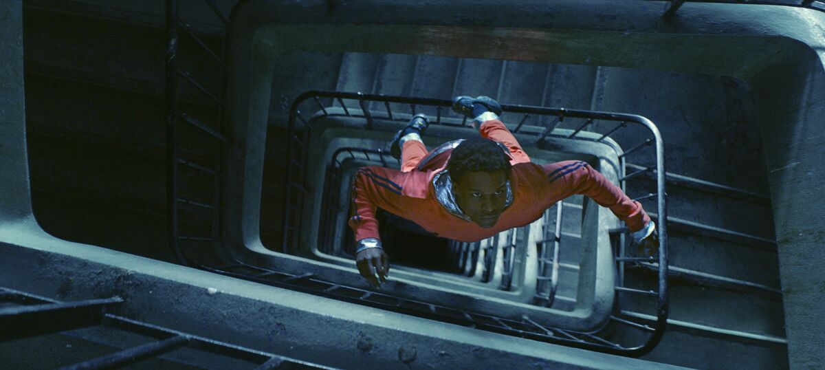 A teenager in a makeshift spacesuit floats in a stairwell in the movie 'Gagarine.'