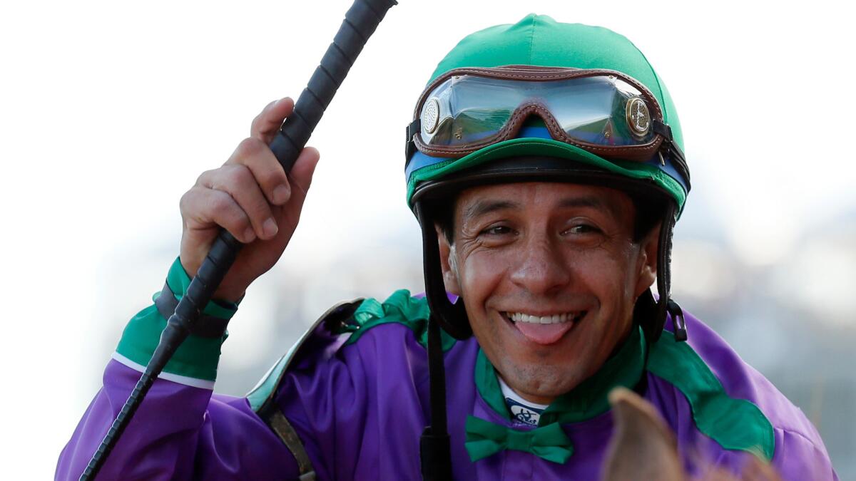 Jockey Victor Espinoza smiles while sitting on top of California Chrome following his victory at the Kentucky Derby on May 3.