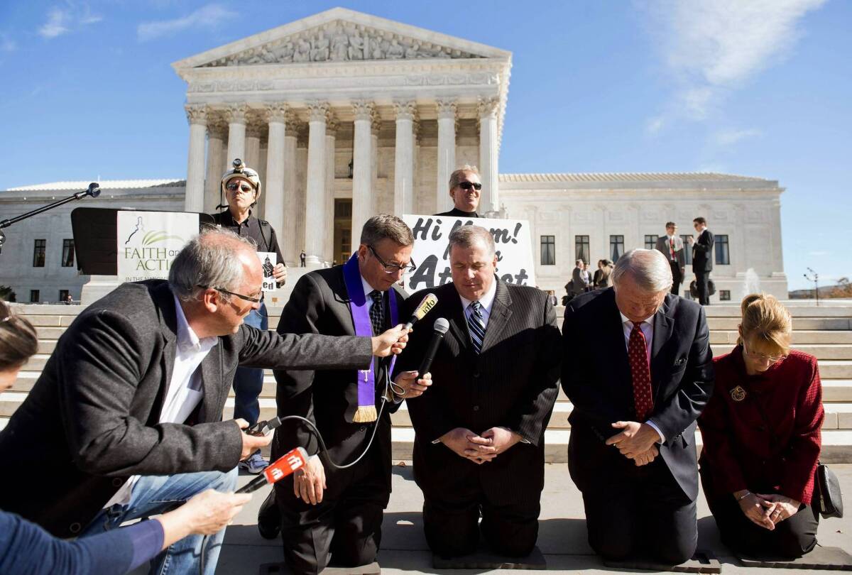 Religious activists pray outside the Supreme Court after oral arguments in the case of Town of Greece vs. Galloway.