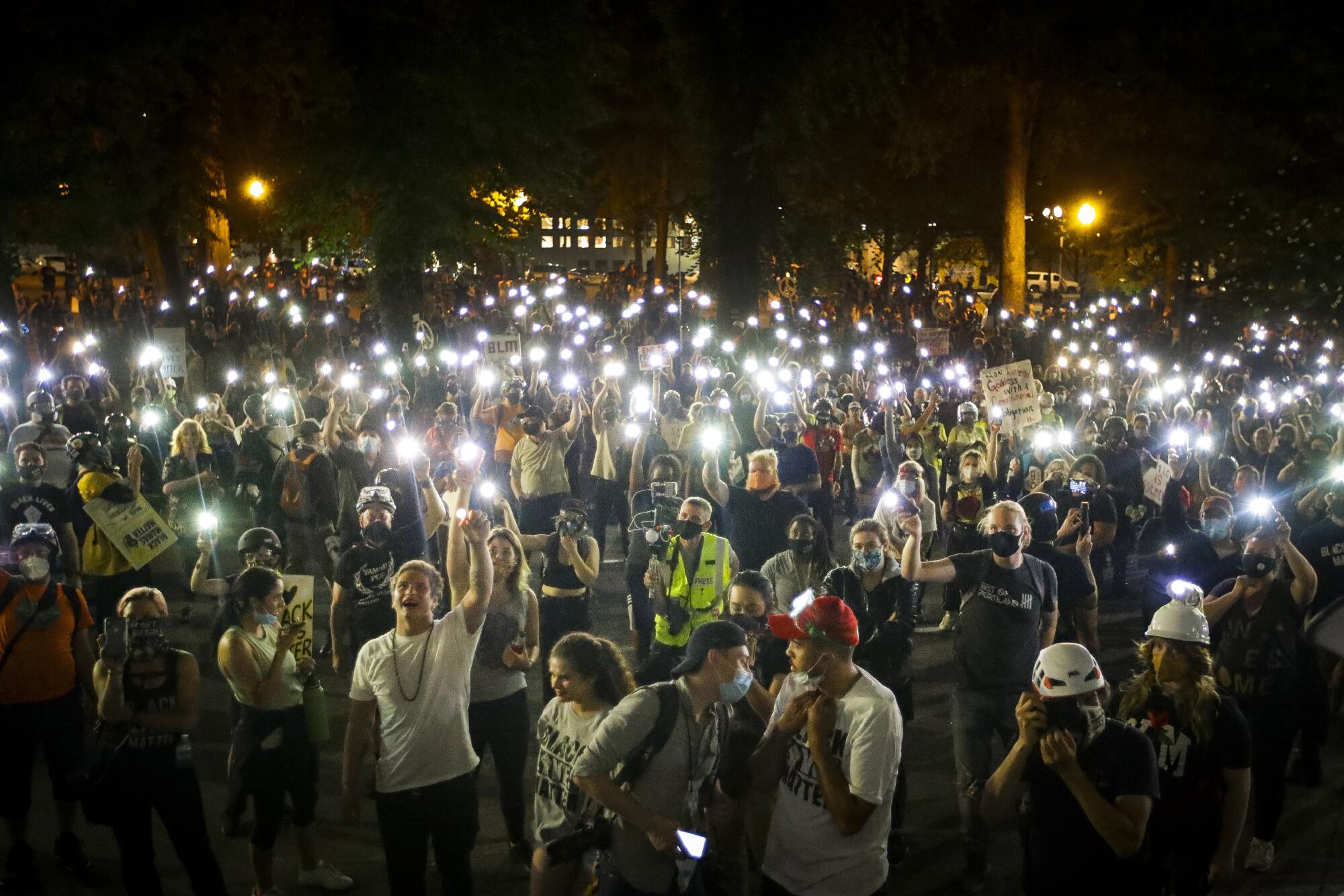 Demonstrators raise their cellphone lights as they chant slogans.