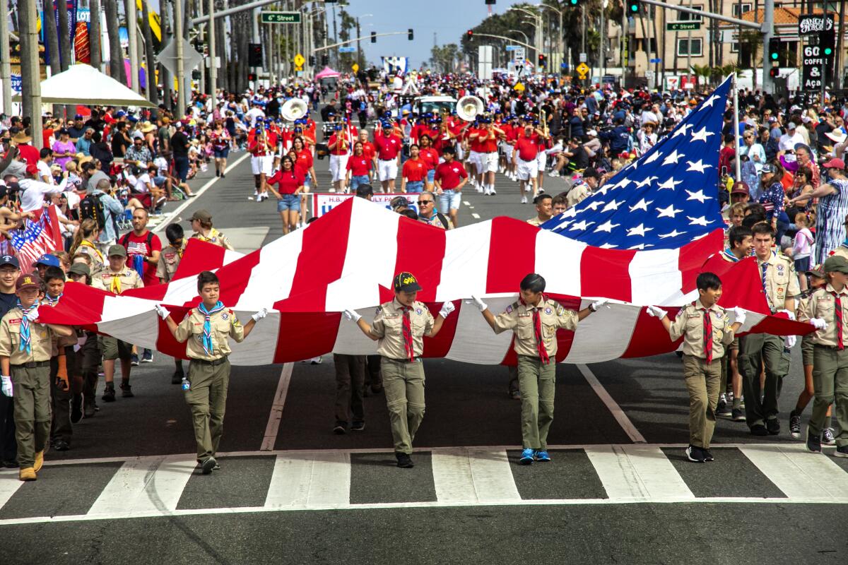 Boy Scouts carry an American flag in the Huntington Beach Fourth of July parade.