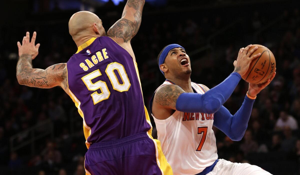 Knicks forward Carmelo Anthony tries to score on a drive down the lane against Lakers center Robert Sacre during a game last season.