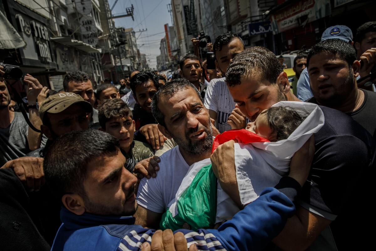 Family members carry the body of Layla Ghandour, 10 months, to her burial site in Gaza City.