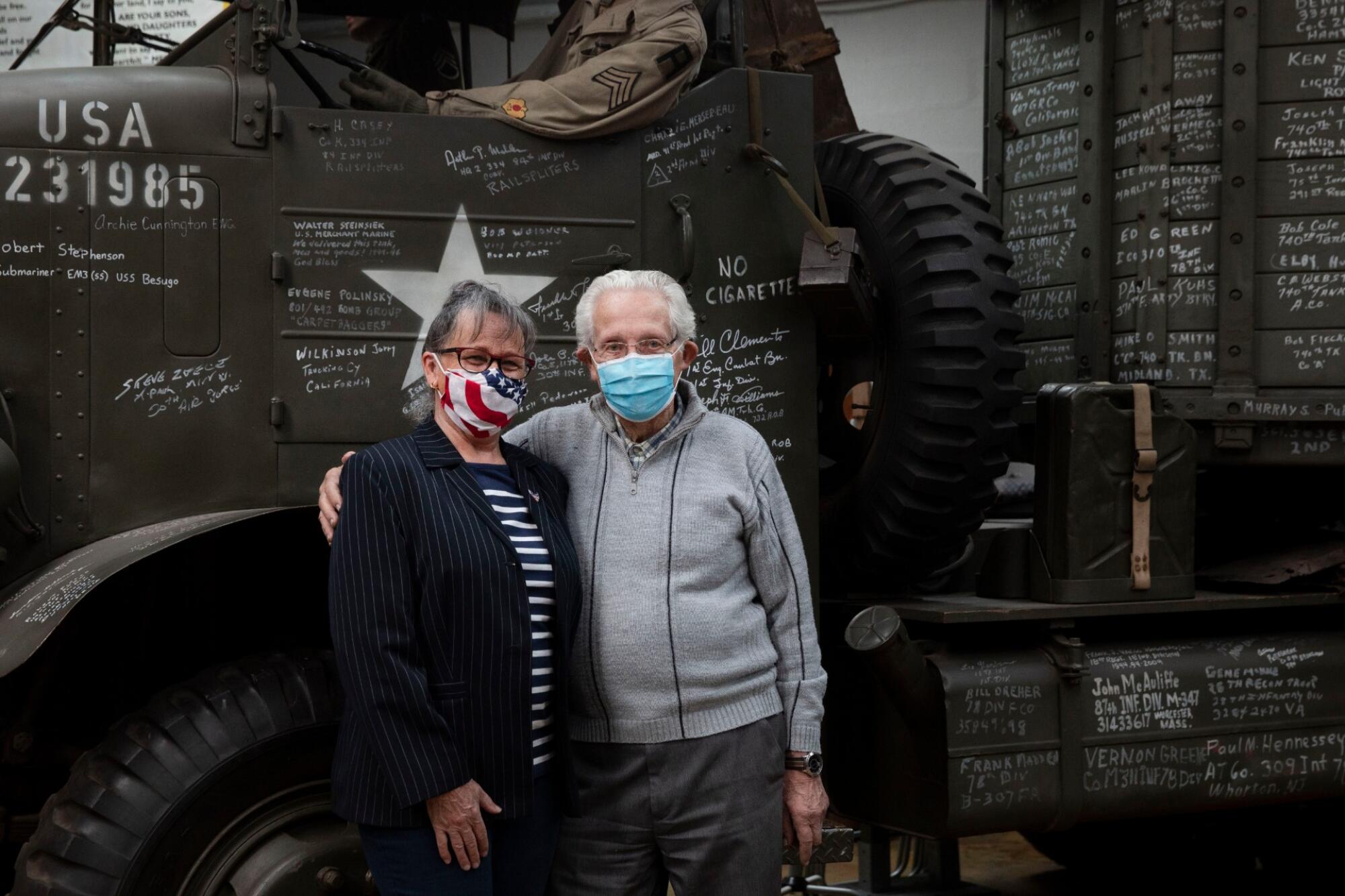Marcel Schmetz, right, and his wife, Mathilde, pose in front of a World War II vintage truck with their masks on in Thimister-Clermont, Belgium.
