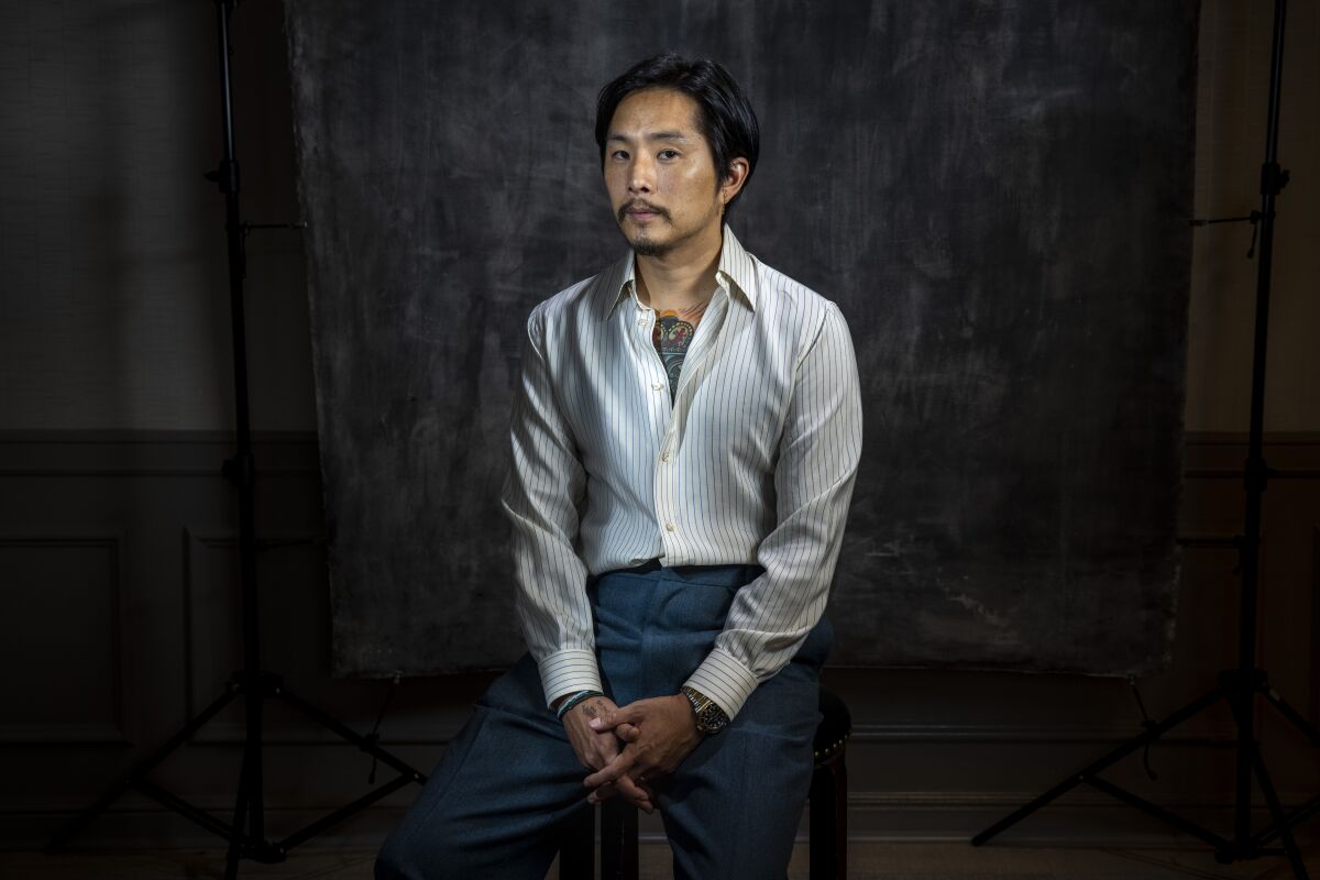 Director and actor Justin Chon, seated, is photographed for his new film, "Blue Bayou," 