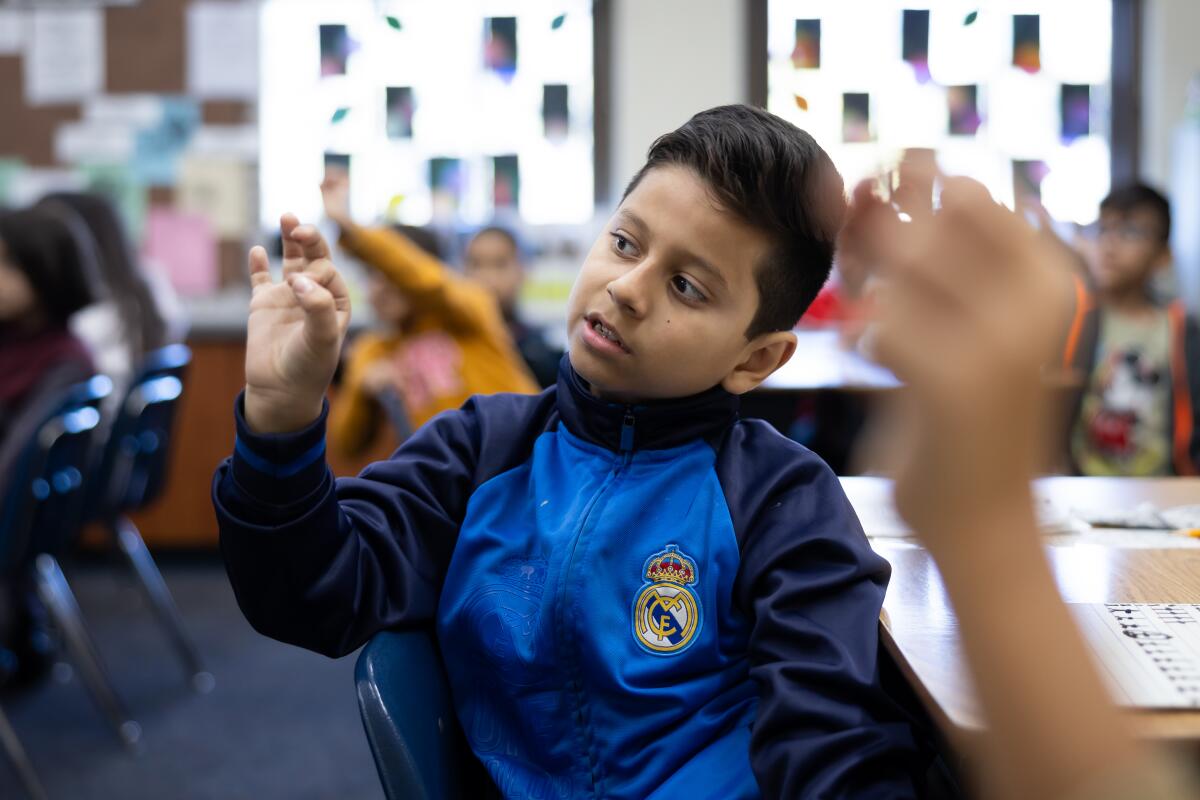 A student holds his hands as if holding a pencil