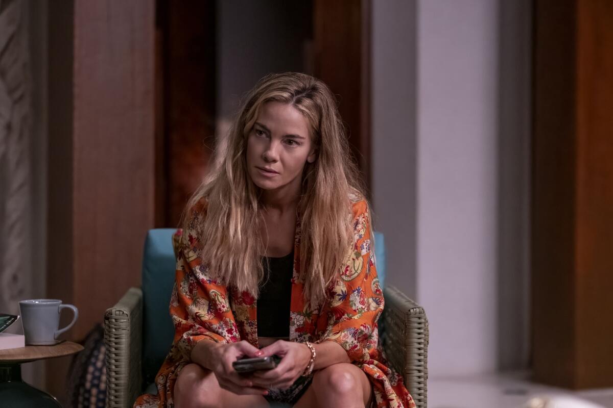 A pistillate successful a floral robe sitting connected a bluish chair.