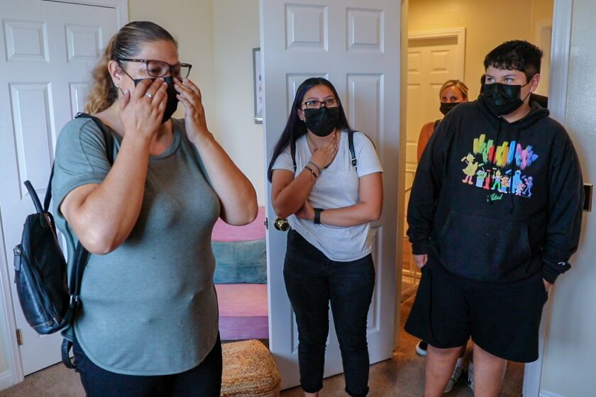 Chula Vista, CA - July 30: Clara Ibarra and her kids Natalia Ibarra, 19, and Nicolas, 15, walk into the master bedroom for the first time after being furnished by Humble Design on Friday, July 30, 2021 in Chula Vista, CA. (Jarrod Valliere / The San Diego Union-Tribune)