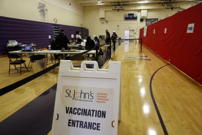 LOS ANGELES, CA - MAY 17: Students are checked in to be vaccinated with Pfizer at the Manual Arts High School basketball and gym building in downtown on Monday, May 17, 2021 in Los Angeles, CA. The school is one of 200 sites that the Los Angeles Unified School District has deployed mobile vaccination teams to get as many shots into students' arms as possible. (Dania Maxwell / Los Angeles Times)