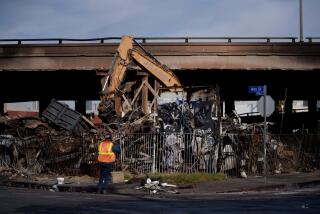 LOS ANGELES CA NOVEMBER 13, 2023 - Crews clear debris from the site of a fire under Interstate 10 in Los Angeles, California. (Eric Thayer / For The Times)