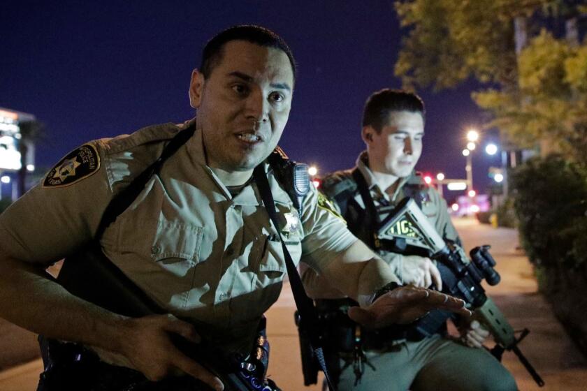 FILE - In this Oct. 1, 2017 file photo, police officers advise people to take cover near the scene of a shooting near the Mandalay Bay resort and casino on the Las Vegas Strip in Las Vegas. The Nevada Supreme Court has rejected a Las Vegas police bid to delay the release of records about the Oct. 1 mass shooting, including officer body camera videos, 911 recordings, evidence logs and written interview reports. Five of seven justices said Friday, April 27, 2018 the Las Vegas Metropolitan Police Department should make public the records that several media entities hope will shed light on the investigation of the deadliest mass shooting in modern U.S. history. (AP Photo/John Locher, File)