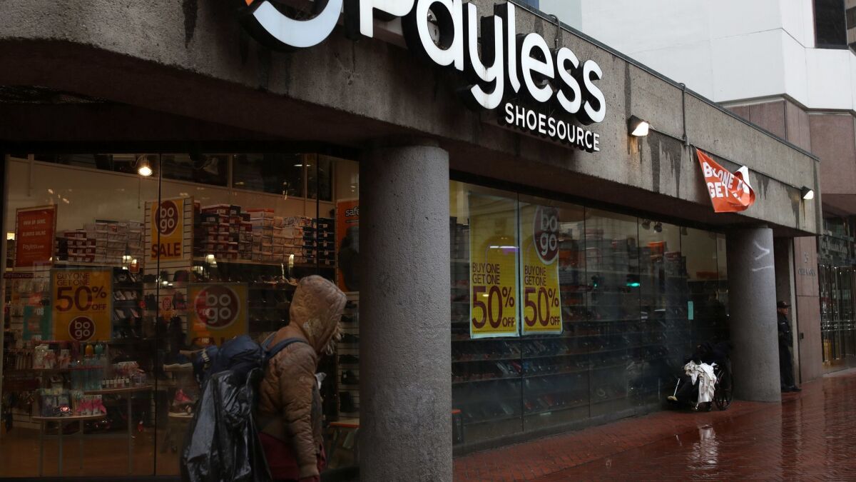 A pedestrian walks by a Payless Shoe store Feb. 8 in San Francisco. Payless is closing all of its U.S. stores.