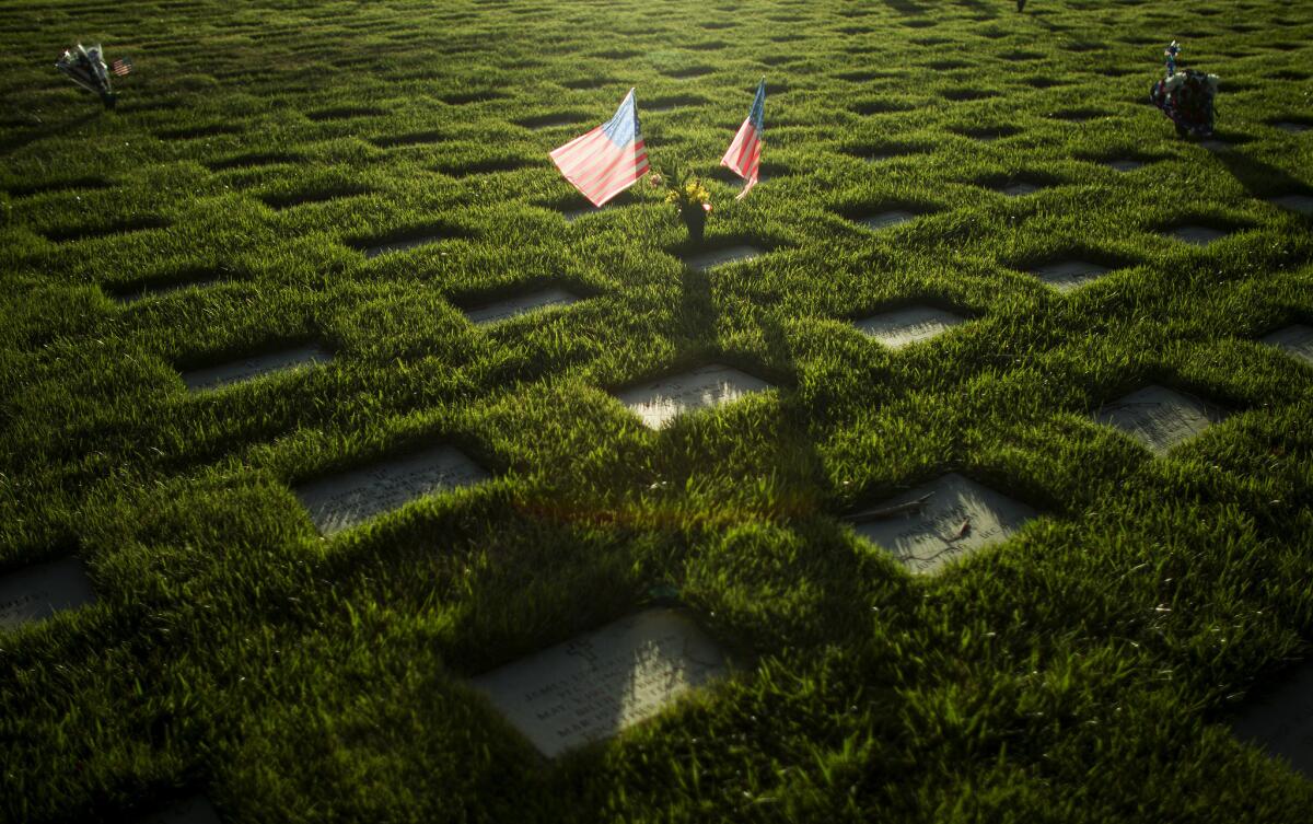 Two American flags blow in the wind above the grave of a veteran at Riverside National Cemetery. The Legislature approved Monday a plan for a new veterans cemetery in Orange County.