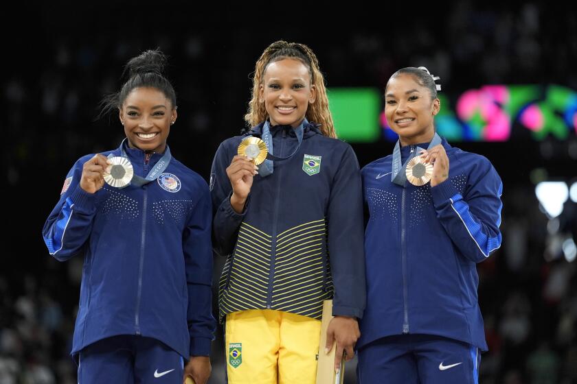 La brasileña Rebeca Andrade (centro) exhibe su medalla de oro, junto a las estadounidenses Simone Biles (izquierda) con plata y Jordan Chiles con bronce en el ejercicio de piso de los Juegos Olímpicos de París, el lunes 5 de agosto de 2024. (AP Foto/Abbie Parr)